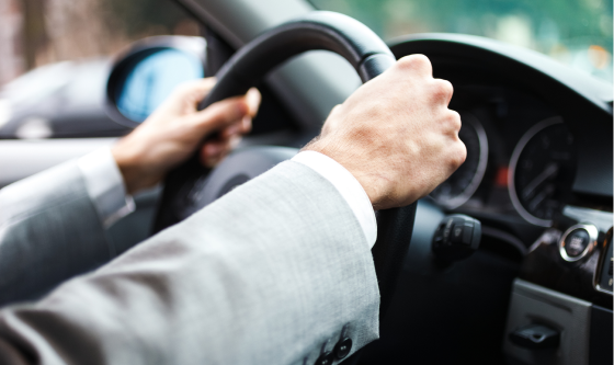 Anonymous male driver holding steering wheel while driving car